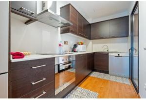 a kitchen with brown cabinets and a white appliance at Apartamentos de Miguel in Vinebre +6 photos