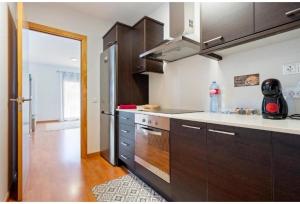 a kitchen with brown cabinets and a stove top oven at Apartamentos de Miguel in Vinebre