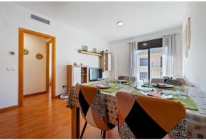 a dining room with a table and chairs and a room with a window at Apartamentos de Miguel in Vinebre