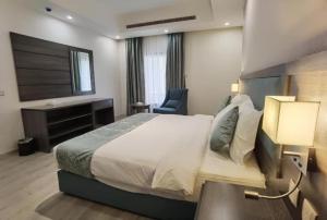 een hotelkamer met een groot bed en een stoel bij شقق عائلتي - My family's apartments in Jeddah