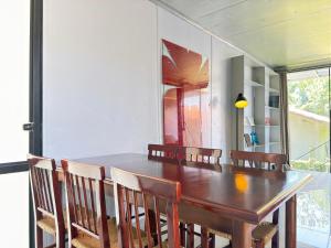 a dining room with a wooden table and chairs at Casa Container Moderna com Vista da Natureza em Itajaí in Itajaí
