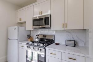 a white kitchen with a stove and a microwave at 1 Berkeley - Entire Apartment - Private, Spacious in Berkeley