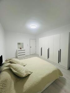 a bedroom with a large bed and white cabinets at City View Apartment in Mitrovicë
