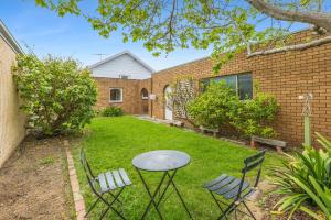 ein Tisch und Stühle im Hof eines Hauses in der Unterkunft Beach Street in Queenscliff