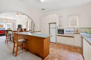 eine Küche mit weißen Schränken und einer großen Insel in der Unterkunft Beach Street in Queenscliff