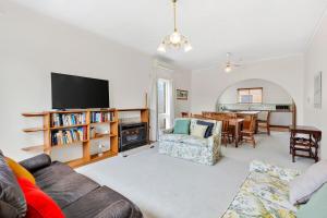 ein Wohnzimmer mit Sofa und Fernseher in der Unterkunft Beach Street in Queenscliff