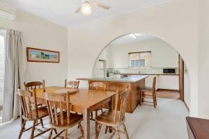 eine Küche und ein Esszimmer mit Tisch und Stühlen in der Unterkunft Beach Street in Queenscliff + 6 Fotos