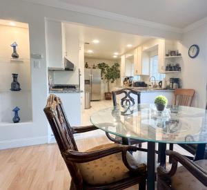 Un comedor y una cocina con una mesa de cristal y sillas. en Downtown San Jose Airport Shared Home, en San José