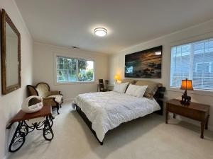 1 dormitorio con 1 cama, 1 silla y 2 ventanas en Downtown San Jose Airport Shared Home, en San José