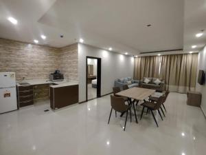 een keuken en een woonkamer met een tafel en stoelen bij شقق عائلتي - My family's apartments in Jeddah