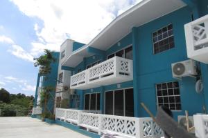 ein blaues Gebäude mit weißen Balkonen darauf in der Unterkunft 301 Batts Rock Beach Condos in Saint Michael