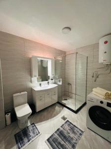 a bathroom with a toilet and a sink and a shower at City View Apartment in Mitrovicë