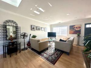 Una sala de estar con dos sofás y un televisor. en Downtown San Jose Airport Shared Home, en San José