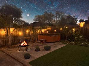 un patio trasero con una hoguera en el patio por la noche en Downtown San Jose Airport Shared Home, en San José