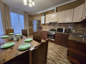 een keuken met een houten tafel met groene borden erop bij Royal Residence Uzhhorod in Oezjhorod +37 foto's