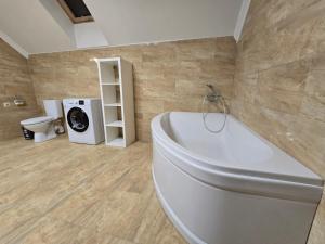 een badkamer met een bad en een wasmachine bij Royal Residence Uzhhorod in Oezjhorod