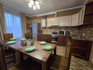 een keuken met een houten tafel met groene borden erop bij Royal Residence Uzhhorod in Oezjhorod