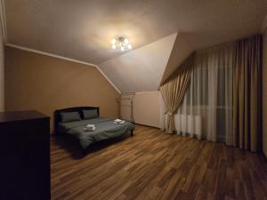 een slaapkamer met een bed in een kamer met een plafond bij Royal Residence Uzhhorod in Oezjhorod