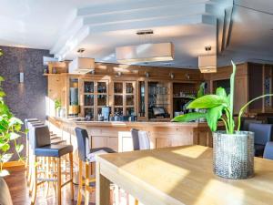 a bar in a restaurant with a table and chairs at Atomis Hotel Munich Airport by Mercure in Oberding +75 photos