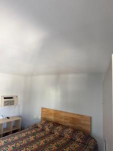 una camera da letto con un letto e una parete bianca di Casa Motel a Los Angeles