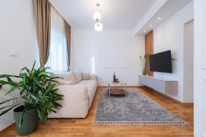 ein Wohnzimmer mit Sofa und Fernseher in der Unterkunft Quince Apartments in Podgorica