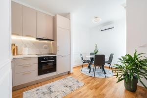 eine Küche und ein Esszimmer mit Tisch und Stühlen in der Unterkunft Quince Apartments in Podgorica