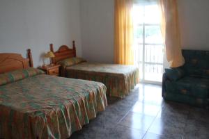 En eller flere senge i et værelse på Hostal El Mirador
