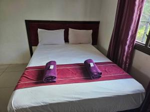 un letto con pantofole viola sopra di Sunshine Villas 