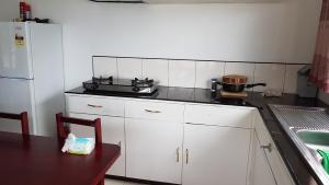 una cucina con mobili bianchi e un forno a piano cottura di Sunshine Villas 