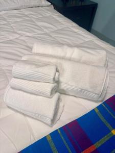 einen Haufen weißer Handtücher auf einem Bett in der Unterkunft Amazing Home away from Home in Sainte-Catherine