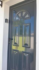 a blue door with a window on it at Hébergement T3 COSY WOUSIRE in Les Abymes