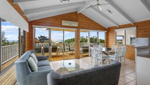 un soggiorno con tavolo e sedie e una cucina di Dolphin a Apollo Bay