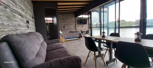 een woonkamer met een bank en een tafel met stoelen bij Villa Lake Blue in El Peñol +53 foto's