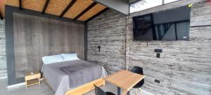 een slaapkamer met een bed en een tv aan de muur bij Villa Lake Blue in El Peñol