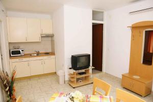 un soggiorno con cucina e TV di Apartment Brna 1 a Brna