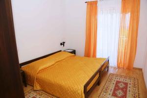 una camera da letto con un letto con copriletto arancione di Apartment Brna 1 a Brna