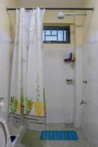 a bathroom with a shower curtain with plants on it at Nanyukihomes3 in Nanyuki