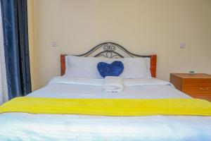 a bed with a blue heart pillow on it at Nanyukihomes3 in Nanyuki