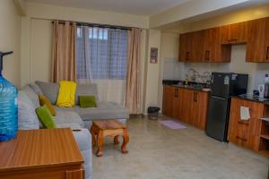 a living room with a couch and a kitchen at Nanyukihomes3 in Nanyuki +6 photos