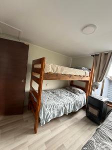 um quarto com dois beliches e uma cama em Cabañas a 7 minutos centro Papudo 
