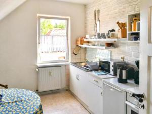 une petite cuisine avec un comptoir et une fenêtre dans l'établissement Villa Charlotte, à Bad Suderode