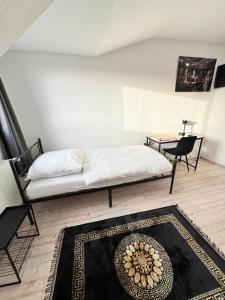 una camera con un letto, un tavolo e un tappeto di Gröpelinger Guesthouse a Brema
