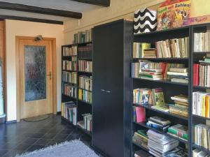 une pièce avec deux étagères noires remplies de livres dans l'établissement Villa Charlotte, à Bad Suderode 2 autres photos