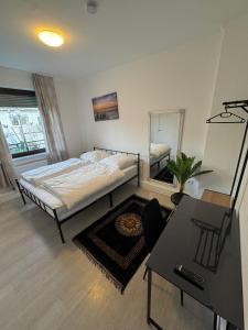 una camera da letto con un letto, un tavolo e uno specchio di Gröpelinger Guesthouse a Brema