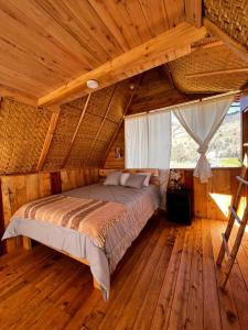 Sigchos Lodge في Sigchos: غرفة نوم مع سرير في غرفة خشبية