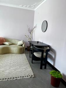 a living room with a couch and a table at The Cozy Home Apartment in Fort Portal