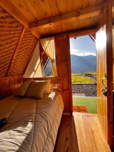 Sigchos Lodge في Sigchos: سرير كبير في غرفة مع نافذة كبيرة