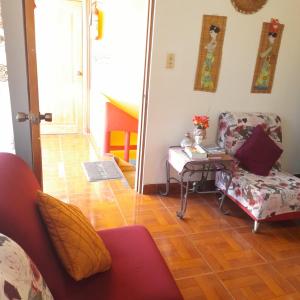 a living room with a chair and a table at Hostal Dorys Mar in Puerto Baquerizo Moreno