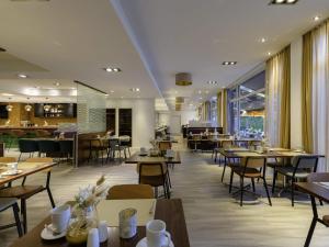 Un comedor con mesas y sillas y un restaurante. en Mercure Aachen Europaplatz, en Aachen