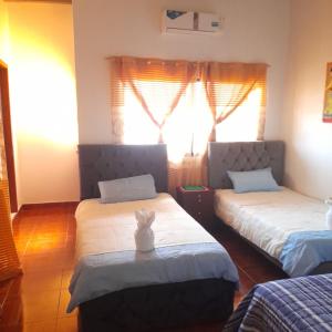 a bedroom with two beds and a rabbit on a table at Hostal Dorys Mar in Puerto Baquerizo Moreno